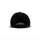 Black baseball cap with adjustable brass buckle strap, viewed from behind on a white background.